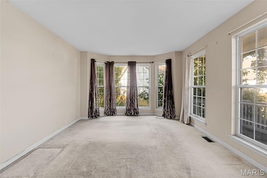 Carpeted spare room featuring baseboards