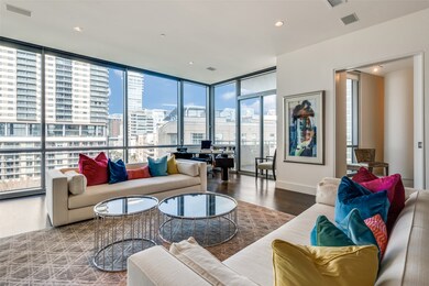 Living room with floor to ceiling windows, wood finished floors, a city view, and recessed lighting