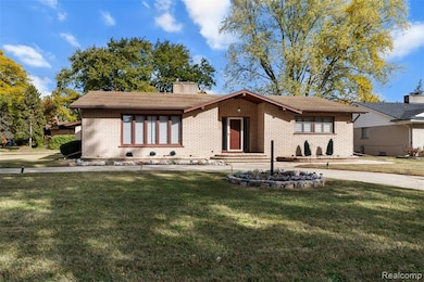 Mid-century home with a front yard, brick siding, and a chimney