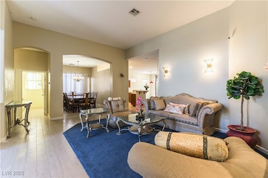 Living room featuring vaulted ceiling, baseboards,