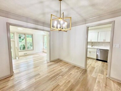 Unfurnished dining area featuring ornamental molding, light wood-style flooring, a chandelier, and a textured ceiling