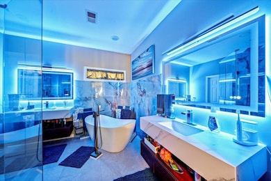 Full bath featuring a freestanding tub, vanity, and tile walls