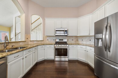 Kitchen features granite countertops, tile backsplash, and stainless steel appliances.