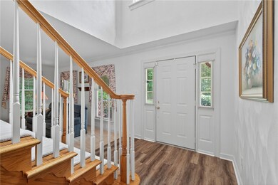 Entrance foyer with dark wood-style floors and stairway