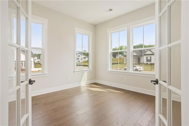 Spare room featuring french doors, wood finished floors, and plenty of natural light