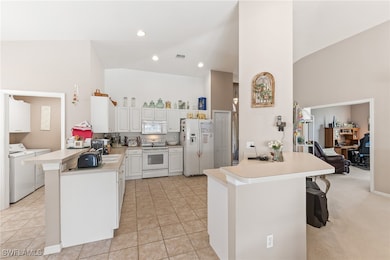 Kitchen featuring high vaulted ceiling, light coun