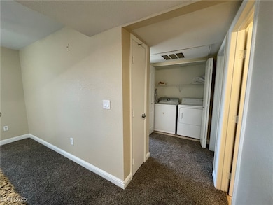 Corridor with attic access, visible vents, baseboa