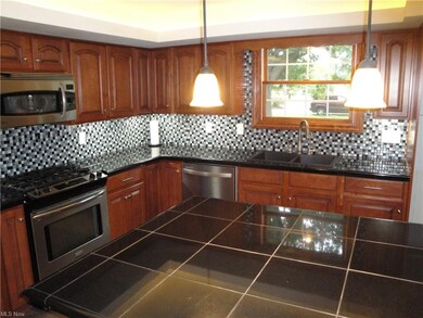 Gorgeous cherry kitchen with glass tile backsplash