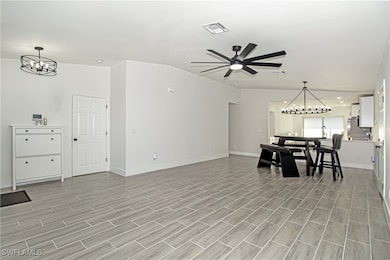 Living room with ceiling fan with notable chandeli