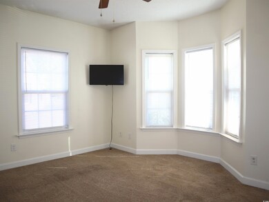 Unfurnished room featuring ceiling fan and carpet 
