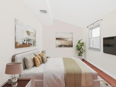 Bedroom with lofted ceiling and wood finished floors