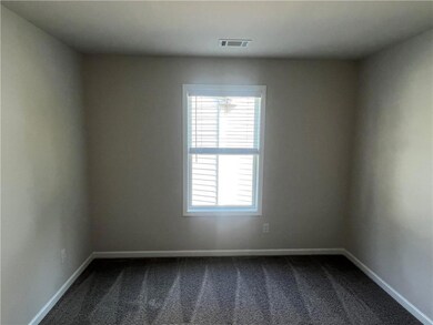 Empty room featuring dark carpet and baseboards