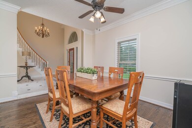 Off of the left side of the foyer, this freshly repainted formal dining room features double crown molding, a lighted ceiling fan, crisp white chair rail molding, hardwood floors, and convenient direct access to the island kitchen.