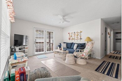 Carpeted living room featuring ceiling fan, a text