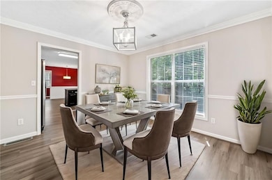 Dining space with a chandelier, baseboards, visibl