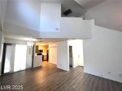 Unfurnished living room with a towering ceiling, d