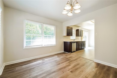 Kitchen featuring dark brown cabinetry, a chandeli
