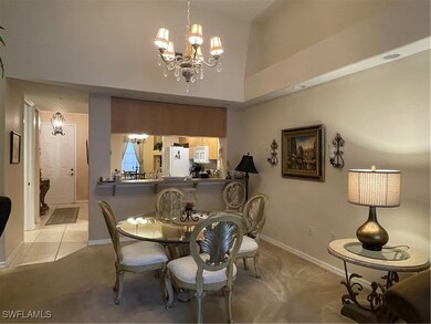 Dining space with a chandelier and light carpet