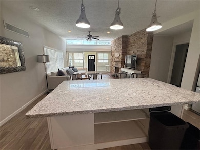 Kitchen with dark wood-style flooring, a textured