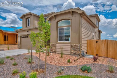 View of front of property with stone siding, concrete driveway, and an attached garage