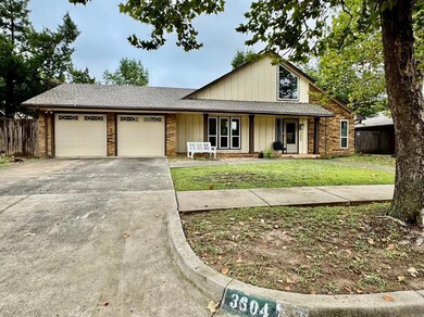 View of front of property featuring a shingled roof, concrete driveway, covered porch, an attached garage, and brick siding