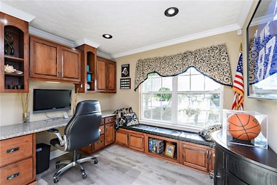 Custom built office with granite desktop custom built cabinets and window seat.