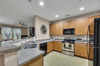 Kitchen featuring black appliances, a ceiling fan, recessed lighting, and a peninsula
