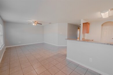 Unfurnished room with arched walkways, light tile patterned floors, and a ceiling fan