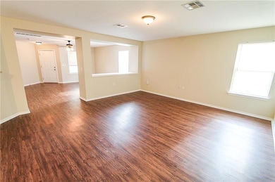 Unfurnished room with dark wood-type flooring and a ceiling fan