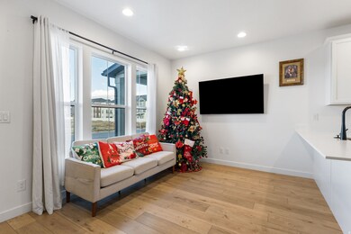 Living area with light wood finished floors and recessed lighting