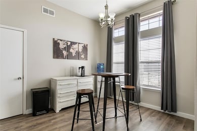 Office with an inviting chandelier and dark hardwood / wood-style flooring