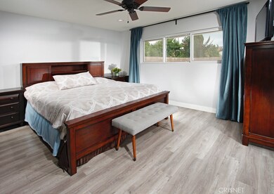 The bright and spacious master suite is enriched by recessed lighting, a large picture window, ceiling fan, large walk-in closet and lustrous wood laminate floors; plus a sumptuous en suite bathroom with contemporary vanity, framed dressing mirror an