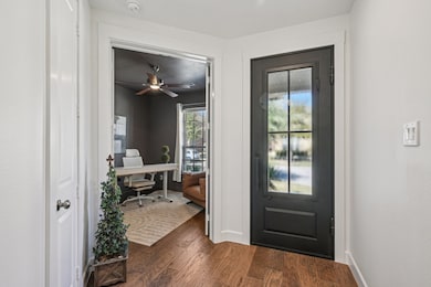Entryway with office, dark wood flooring and iron door