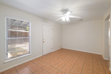 Empty room featuring a ceiling fan and light tile