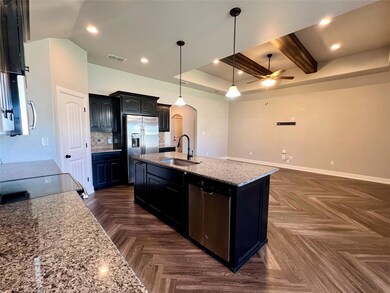 Kitchen featuring ceiling fan, a kitchen island wi