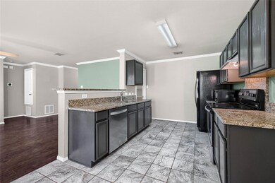Kitchen with dishwasher, black range with electric stovetop, crown molding, and light stone counters