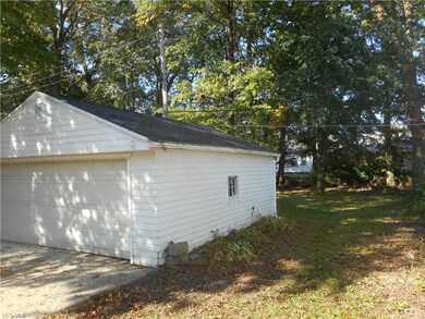 The garage has a gable roof & gutters.