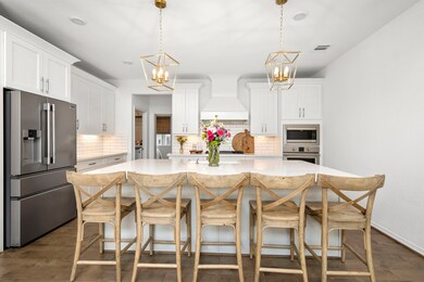 This kitchen is a dream!  Stylish fixtures, gorgeous white cabinets, huge island with seating for 5.  Hardwood floors continue into this space as well as subway tile back splash.