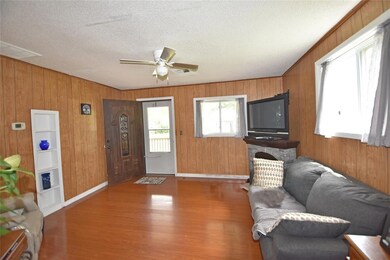 Living room with a textured ceiling, wood-type flo