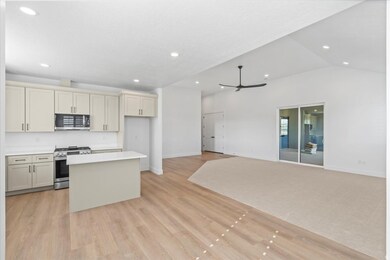 Kitchen featuring cream cabinets, appliances with stainless steel finishes, a kitchen island, a ceiling fan, and recessed lighting