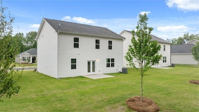 Back of house with a yard and a patio