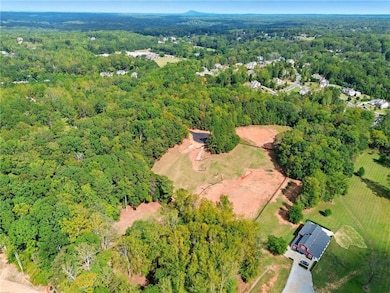 Aerial view of property's location with a heavily wooded area