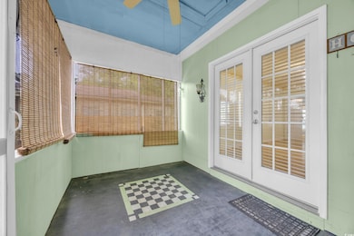 Unfurnished sunroom with french doors and ceiling fan