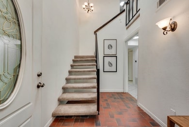Entryway featuring stairs and brick patterned floors