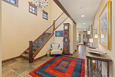 Tiled entryway featuring a chandelier