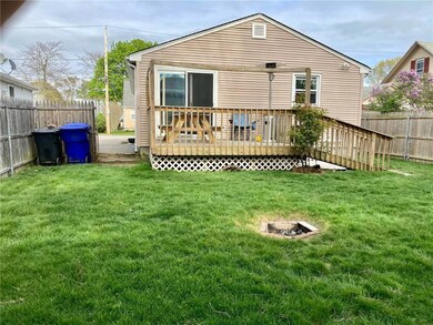 Rear view of the ample yard with a fire pit and su