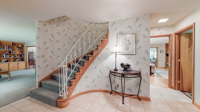Enter through the double entry doors to this inviting foyer with a very unique curving staircase
