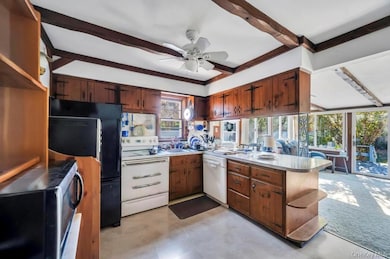 Kitchen featuring open shelves, white appliances, beam ceiling, a peninsula, and light countertops