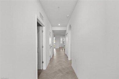 Corridor with visible vents, arched walkways, and baseboards