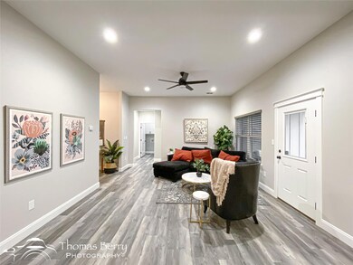 Living room with ceiling fan and light hardwood / 